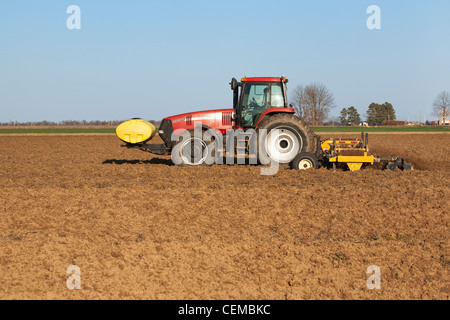 Un trattore Case IH campo e implementare terminare i lavori di preparazione del terreno di un campo in tarda primavera per la piantagione di cotone / Arkansas. Foto Stock