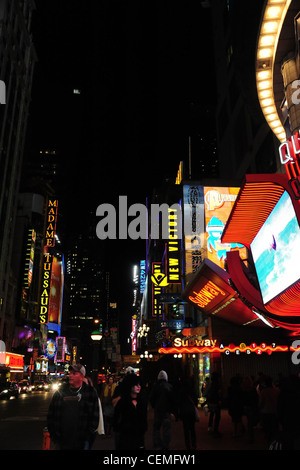 Notte ritratto al neon, al museo delle cere di Madame Tussauds & New Victory Theatre, persone auto fari, West 42nd Street presso la settima Avenue, New York Foto Stock