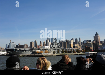 Cielo blu vista sullo skyline di Manhattan grattacieli, del fiume Hudson e turisti in cerca di USS Intrepid portaerei, Pier 86, New York Foto Stock