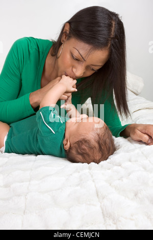 Biracial mom sul letto con il suo nero multietnica figlio bambino (Baby è di 3 mesi di età) Foto Stock