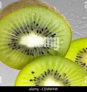 Studio shot che mostra una disposizione particolare di fresco affettato kiwi in ambiente umido Foto Stock