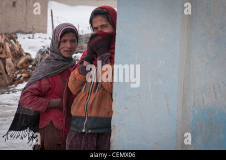 PROVINCIA di KHOWST, Afghanistan - due ragazze locali guardano da dietro un muro nel mercato del legno di Gardez mentre un'unità di smaltimento dell'ordinanza esplosiva dell'esercito nazionale afgano si prepara a detonare un dispositivo esplosivo improvvisato trovato nei pressi di febbraio 18. Questa detonazione è stata storica perché era la prima volta che un'unità di smaltimento dell'ordinanza esplosiva dell'ANA è stata chiamata a distruggere un IED senza l'assistenza delle forze di coalizione. Un'unità Scout statunitense e un'unità EOD della base operativa Forward Gardez hanno supervisionato l'operazione, ma non hanno giocato la mano in essa. Foto Stock