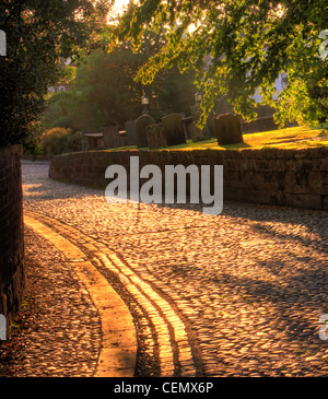 La zona di ciottoli nel villaggio Grappenhall, Sud Warrington al tramonto. (Church Lane, adiacente al St Wilfrids chiesa parrocchiale) Foto Stock