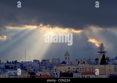 Vista da bastioni, il muro che circonda la città vecchia di Gerusalemme in Israele, della Città Vecchia al tramonto con alberi di luce Foto Stock