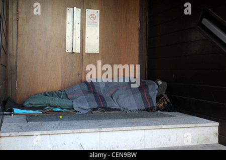 Una persona senza dimora nella foto dorme in un portale in Brighton, East Sussex, Regno Unito. Foto Stock