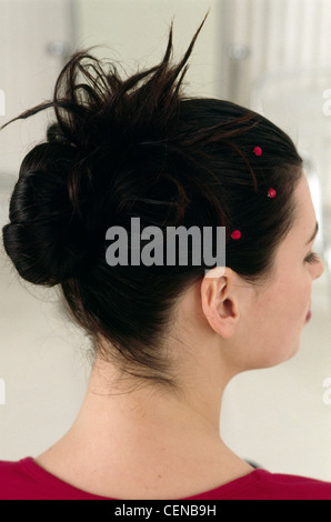 Passo per passo i capelli Updo femmina con brunette capelli intrecciati in un chignon e decorate con rosso di cristalli di diamante Foto Stock