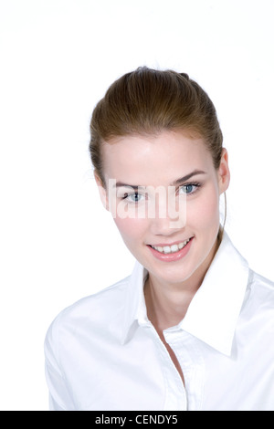 Femmina con capelli castani fuori la sua faccia, indossa una camicia bianca, sorridente, guardando la fotocamera Foto Stock