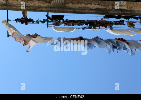 Linea di lavaggio con panni stesi su di esso, lavanderia, guardando in alto nel cielo blu, Lisbona, Portogallo Foto Stock