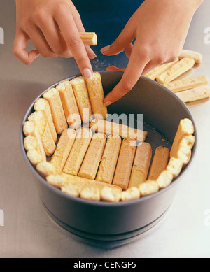 C 'passo dopo passo fragola charlotte' Fodera tortiera con spugna dito biscotti Foto Stock