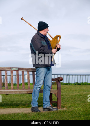 Busker uomo riproduzione di cornamuse con un unico drone a Whitby West Cliff (eventualmente tubazioni svedese) Foto Stock