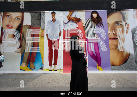 Gli amanti dello shopping passa una promozione per un gap negozio di abbigliamento, coprendo i suoi vetri mentre il negozio è stato rinnovato Foto Stock