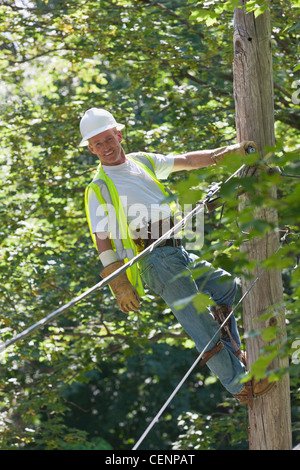 Lineman su un palo lavorando sul telefono e i fili del cavo Foto Stock