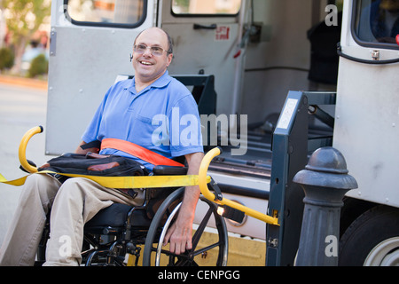 Uomo con Friedreich in sedia a rotelle entra accessibilità del trasporto pubblico Foto Stock