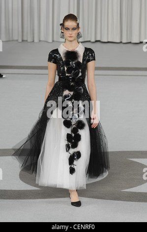 Parigi Haute Couture Chanel Primavera Estate modello capelli biondi off faccia bianca piume indossando jewelled black net attraverso gli occhi e Foto Stock