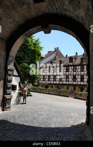 Attraverso l'arco delle mura fortificate della città che conduce a Platz am Tiergärtnertor (Piazza Tiergärtnertor) a Norimberga, Germania. La piazza è molto Foto Stock