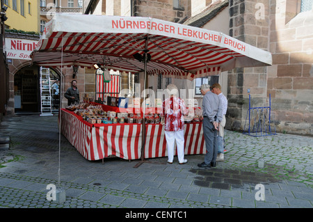 Visitatori di uno dei tanti pan di zenzero in una bancarella di mercato a Norimberga, Germania Foto Stock