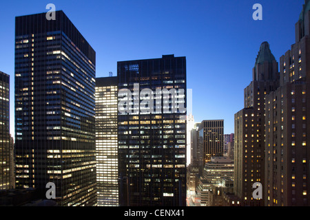 Edifici illuminati fino al tramonto in downtown Manhattan guardando a nord con il Waldorf Astoria di New York City, nello Stato di New York, Stati Uniti d'America Foto Stock