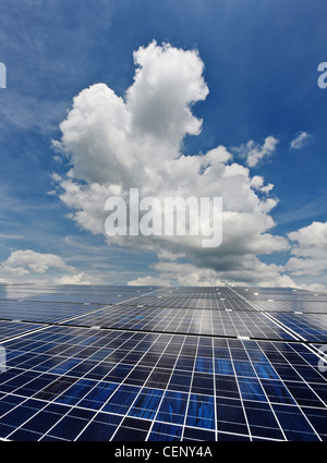 Solare pannelli Pv sembrano tendere a infinito su un tetto di fattoria con nuvole sopra. Foto Stock