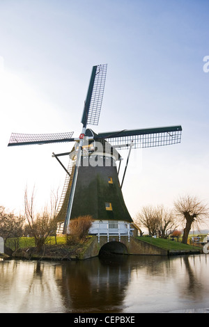 Mulino a vento olandese congelati paesaggio invernale in un pomeriggio soleggiato Foto Stock