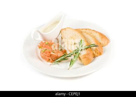 Tar-tar dal salmone pesce con cipolla verde. Servito con salsa di miele e pane bianco tostato. Foto Stock