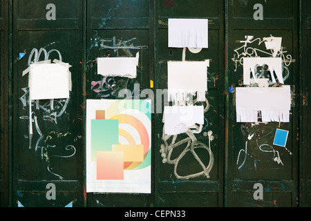 Grungy background - vecchi manifesti stracciati e privati di piccole pubblicità carta verde sulla parete metallica Foto Stock