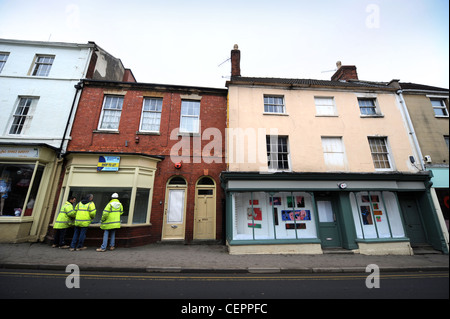 Lavoratori edili guardare in un negozio non occupato in uso temporaneo come una galleria d'arte a Dursley, Gloucestershire, Regno Unito Foto Stock