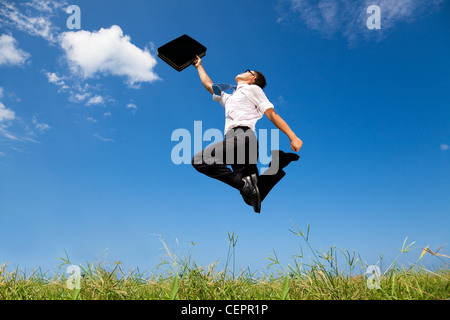 Felice e imprenditore di successo di saltare sul campo Foto Stock