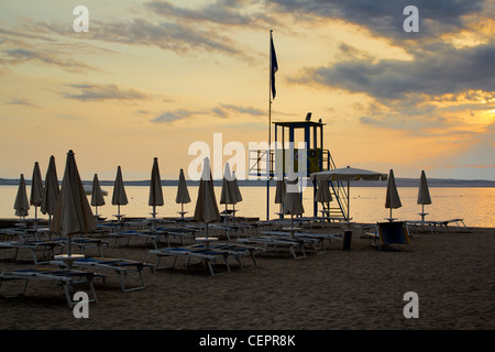 Tramonto sulla spiaggia con lettini e custode delle torri Foto Stock