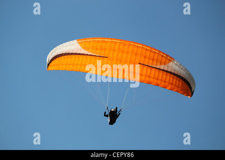 Rosso, bianco e nero, parapendio volare in un profondo cielo blu Foto Stock