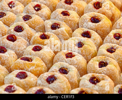 Ready-made ciambelle ricoperte con lo zucchero in polvere su di un vassoio Foto Stock