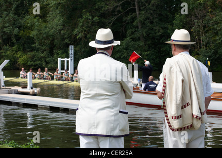 Senior Rowing Club membri in piedi sulla riva a guardare l'inizio di una gara all'annuale Henley Royal Regatta. Foto Stock