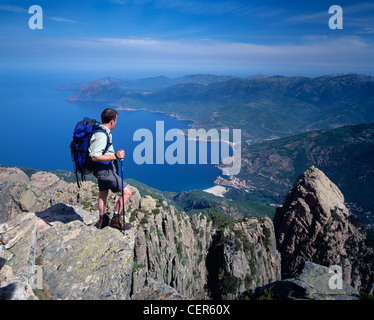 Uomo in piedi sulla cima di Capu d'Orty con vista sul Golfe de Porto, Corsica, Francia. Foto Stock