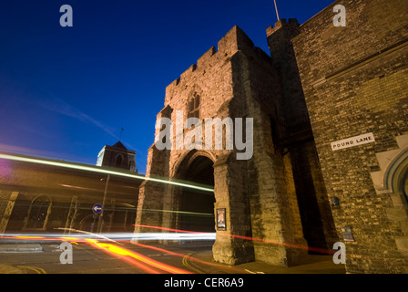 La Torre Westgate in Canterbury illuminata di notte con prove di luce dal traffico in transito. Foto Stock