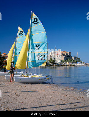 Catamarani su una spiaggia con la cittadella di Calvi dietro. Haute Corse, Corsica, Francia. Foto Stock