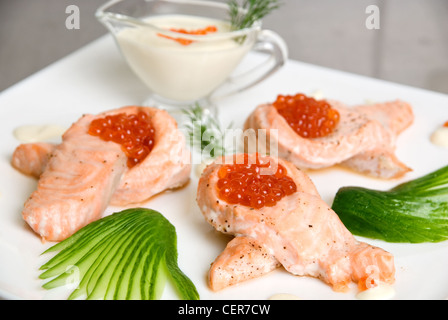 Arrosto di filetto di salmone con caviale rosso, cetrioli e salsa Foto Stock