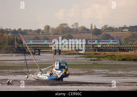 Un treno di attraversare le velme del fiume Stour tra Manningtree e Cattawade. Foto Stock