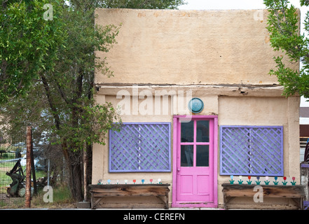 Una rosa porta su un stuccato adobe house sorge sulla strada principale di Fort Sumner, Nuovo Messico. Foto Stock