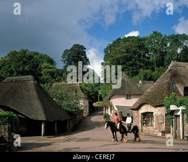 Due persone a cavallo nel villaggio di Cockington. Foto Stock