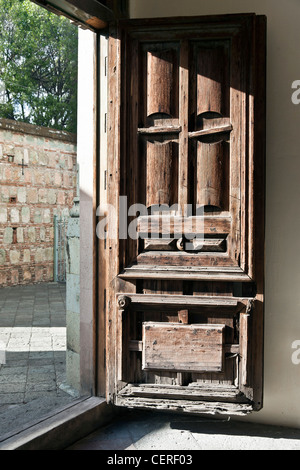 Bella martoriata originale pannellate di legno porta di ingresso è aperta nella chiesa di Patrocinio sul bel pomeriggio Oaxaca Messico Foto Stock