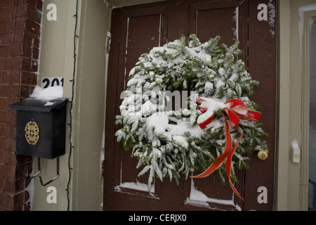 La neve copre un decorato ghirlanda di Natale nel Berkshires del Massachusetts. Foto Stock