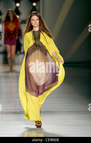 Etro Milano pronto a indossare Primavera Estate Brunette modello femminile i capelli dritti indossando un giallo kaftan viola la stampa batik un Foto Stock