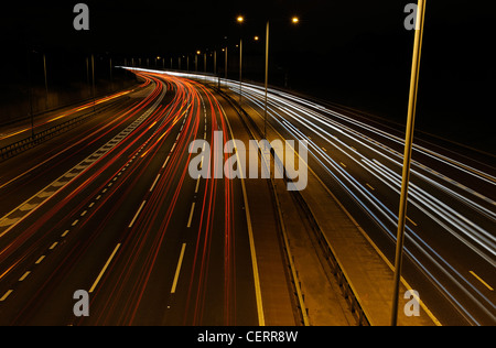 Vista notte da un ponte di luce percorsi da traffico sulla M25 Autostrada. Foto Stock