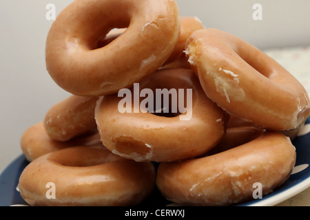 Plain ciambelle Krispy Kreme raffigurato su una piastra in un appartamento di Brighton, East Sussex, Regno Unito. Foto Stock