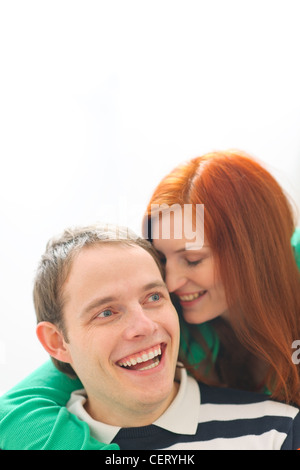 Capelli rossi ragazza whispering in fidanzati orecchio Foto Stock