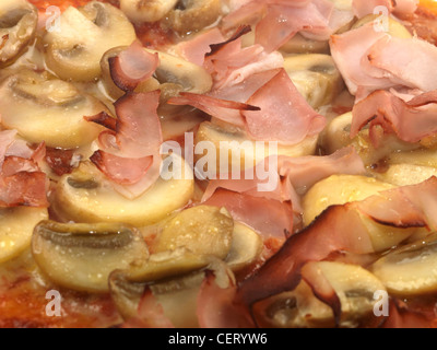 Appena cucinato in stile italiano di prosciutto e funghi pizza vegetariana pronto a mangiare con n. di persone Foto Stock