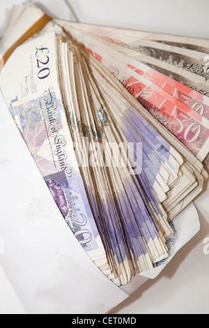 Cinquanta £50 e venti £20 pound GBP banconote in una busta bianca England Regno Unito Foto Stock