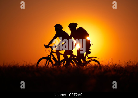 L uomo e la donna in mountain bike Escursioni in bicicletta sulla collina Hambledon sopra il Blackmore Vale, Dorset, England, Regno Unito Foto Stock