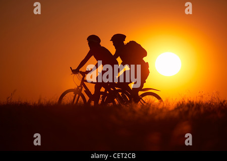 L uomo e la donna in mountain bike Escursioni in bicicletta sulla collina Hambledon sopra il Blackmore Vale, Dorset, England, Regno Unito Foto Stock