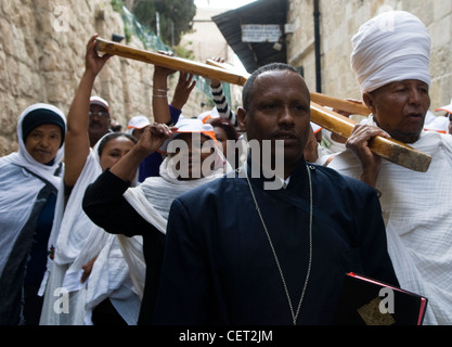 Pellegrini etiope, portando una grande croce di legno in Via Dolorosa sulla processione del Venerdì santo. Foto Stock