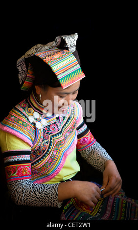 Una donna di Yi indossando variopinti abiti tradizionali. Foto Stock